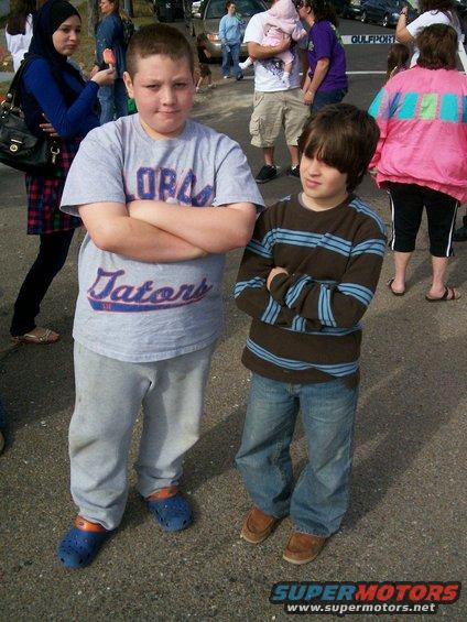 Two boys with arms crossed, one in a Gators shirt, the other in a striped shirt