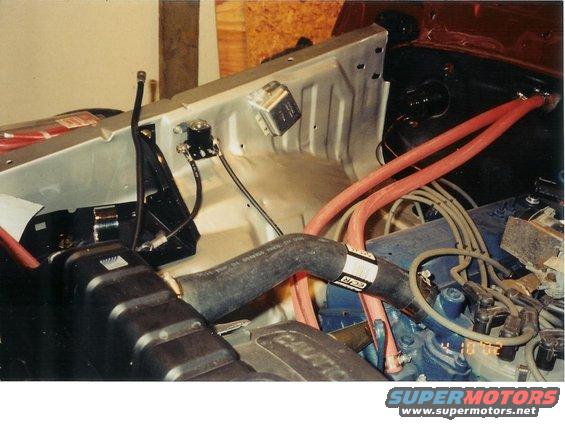 Engine bay with hoses and wiring visible. Some text on a hose reads 'GCR'