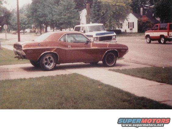 Brown 1970 Dodge Challenger side view with chrome trim and aftermarket wheels