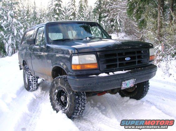 Black 1992 Ford Bronco with lifted suspension and off-road tires in snow