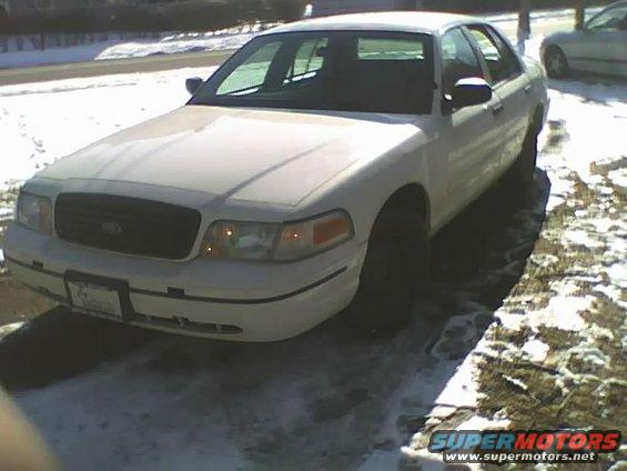 White 2000 Ford Crown Victoria sedan parked on a snowy driveway, front 3/4 view