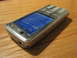 2003 Ford Crown Victoria - A Nokia N82 phone is shown on a wooden table. The screen displays the time and network information.