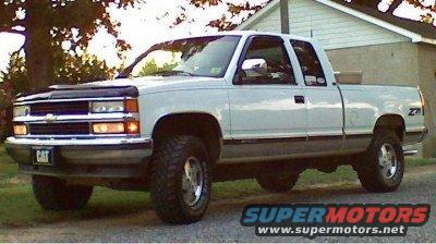 White pickup truck with lifted suspension and off-road tires. Has a CAT logo on the front bumper