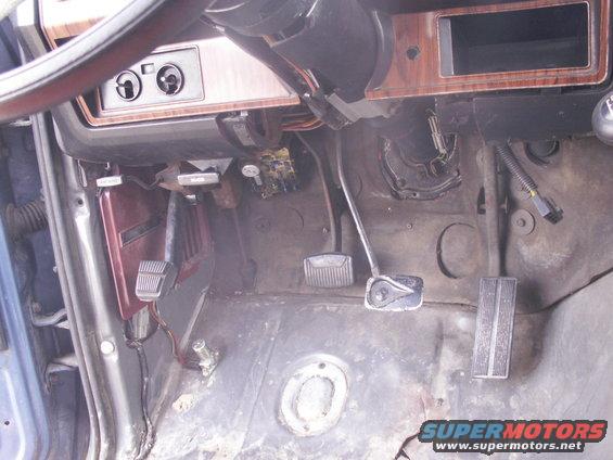 Driver's side footwell with pedals, steering column base, and dashboard trim