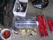 1990 Ford Mustang - Various automotive parts, including Edelbrock valve covers and red suspension components, are displayed on a garage floor.