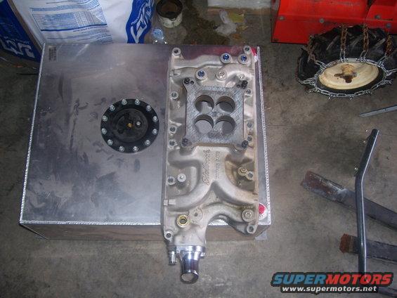 Aluminum fuel tank with black cap next to Edelbrock intake manifold