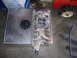 1990 Ford Mustang - An aluminum fuel tank and an Edelbrock intake manifold are displayed on a concrete floor.
