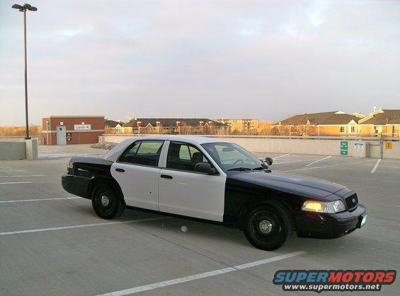2004 Ford Crown Victoria police car, two-tone black and white, parked in a lot