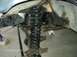 1990 Ford Bronco - The image shows the front suspension and axle of a vehicle, likely undergoing modifications or repairs.