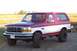 1995 Ford Bronco - This two-tone red and white 1995 Ford Bronco is shown from a 3/4 front angle.