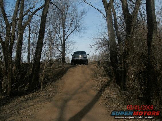 Black SUV on dirt hill, front view. Watermark reads 03/01/2008