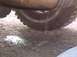 1993 Ford Bronco - Fluid is leaking from the vehicle's undercarriage onto the dirt and puddles.