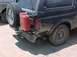 1993 Ford Bronco - Rear view of a black Ford Bronco with a spare tire and a red jerry can attached to the back.