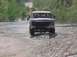 1993 Ford Bronco - 1993 Ford Bronco navigating off-road terrain with water and mud.