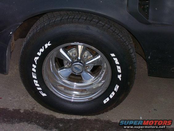 Black car rear wheel with Firehawk Indy 500 tire and chrome five-spoke rim