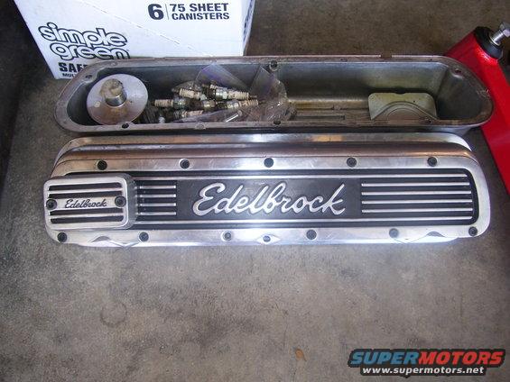 Edelbrock valve covers and a box of spark plugs on a concrete floor