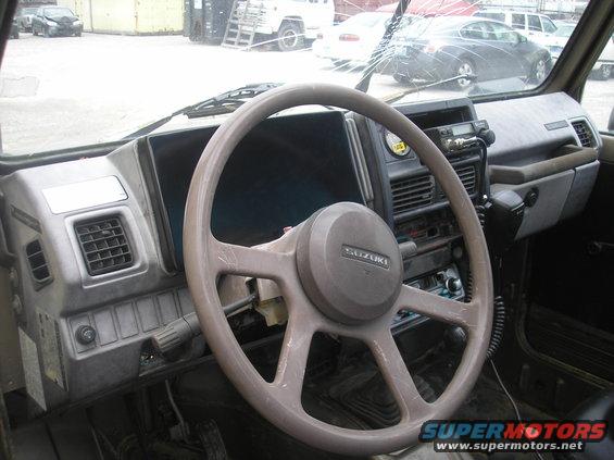 Interior of a 1987 Suzuki Samurai with a cracked windshield and a CB radio mounted on the dash