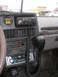 1987 Suzuki Samurai - The interior of a 1987 Suzuki Samurai shows a CB radio, aftermarket stereo, and a gauge on the dashboard.