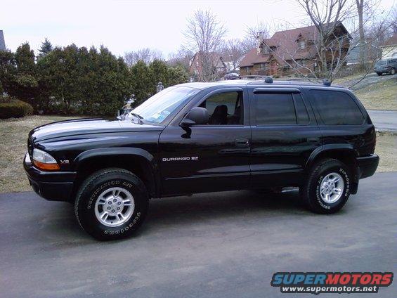 Black SUV parked on a driveway, side view. It has a V8 badge and 'DURANGO 5.9L' on the side
