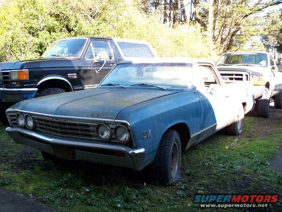 Blue 1967 Chevrolet El Camino with flat tire, parked next to black Ford Bronco and white Ford pickup truck