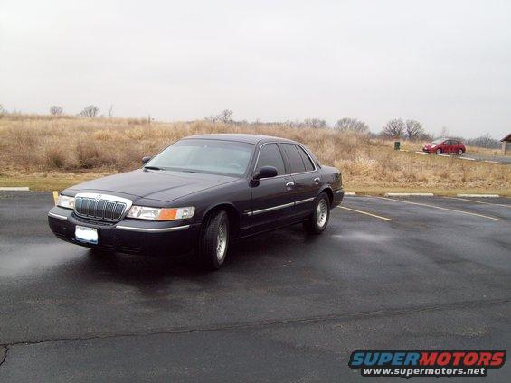 1999 Mercury Grand Marquis parked on wet asphalt, another car in background