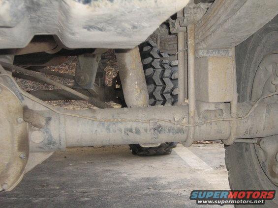 Underside view of a vehicle's rear axle, leaf springs, and tire