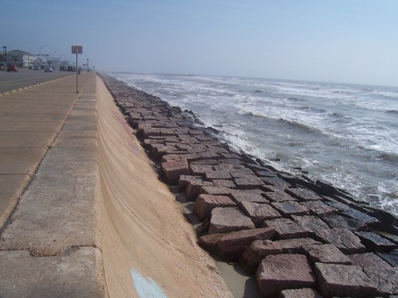 Seawall and ocean waves under a hazy sky