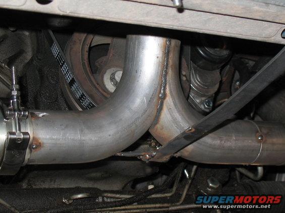 Custom exhaust pipes and serpentine belt visible under a vehicle
