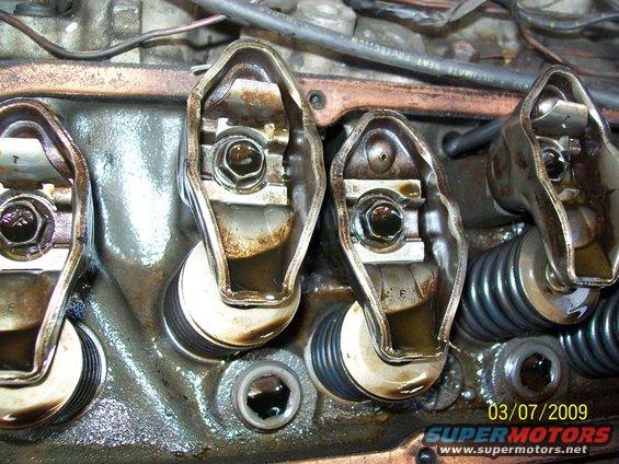 Close-up of engine valve train with rocker arms and springs visible. Date stamp 03/07/2009