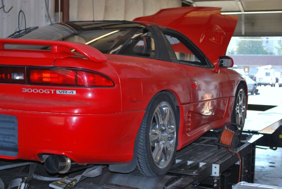 Red 1991 Mitsubishi 3000GT VR-4 on a dynamometer, hood up