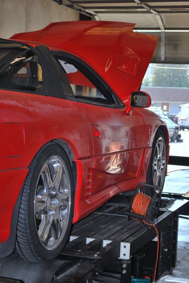Red 1991 Mitsubishi 3000GT on a dynamometer with hood open