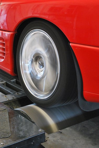 Red 1991 Mitsubishi 3000GT wheel spinning on a dynamometer