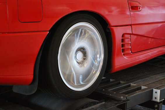 Red car side panel and spinning wheel on a dynamometer