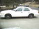 1998 Ford Crown Victoria - Side profile of a white 1998 Ford Crown Victoria sedan parked on a driveway.