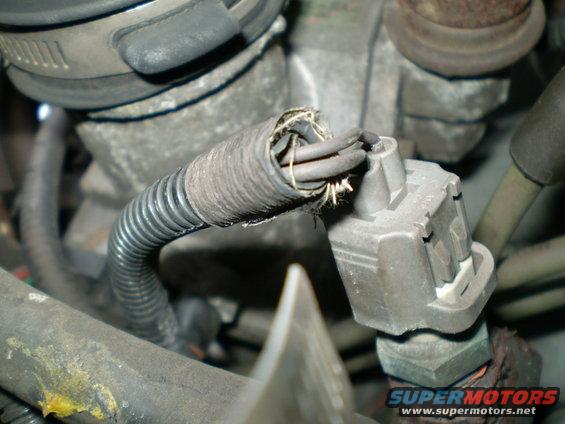 Engine bay shot showing a frayed wiring harness connected to a sensor