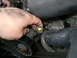 1996 Ford Bronco - Close-up view of a hand disconnecting an electrical connector within the engine bay.