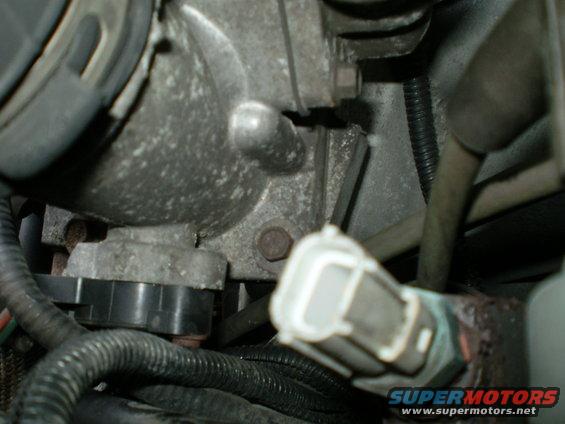 Close-up of engine component with electrical connector and wiring