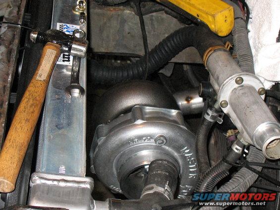 Turbocharger and radiator in engine bay, with a hammer and wrench nearby