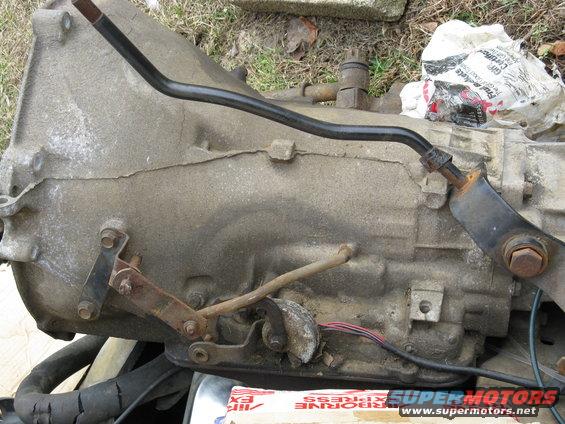 Dirty automatic transmission with linkage and wiring, some paper packaging visible