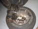 1991 Ford Bronco - A greasy transfer case rests on a Bridgestone tire, with other tires visible in the background.