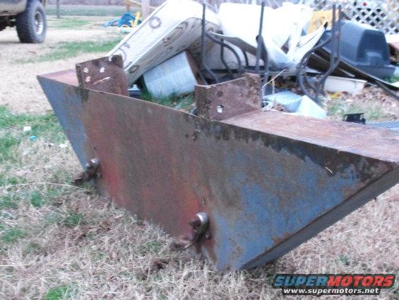 Rusted metal bumper part with blue and red paint remnants