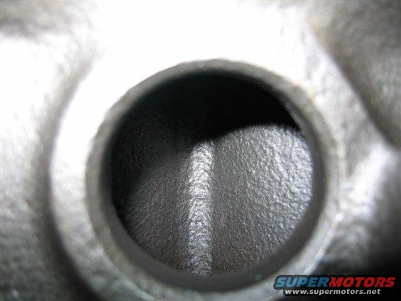 Close-up of an engine cylinder head port, showing the intake or exhaust passage