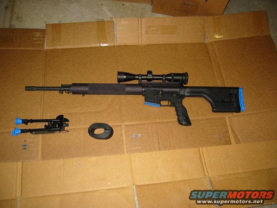 Sniper rifle with scope and bipod on cardboard
