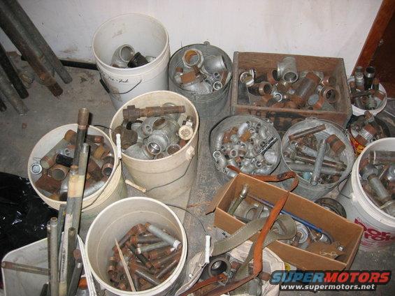 Buckets and boxes filled with various plumbing fittings and pipes