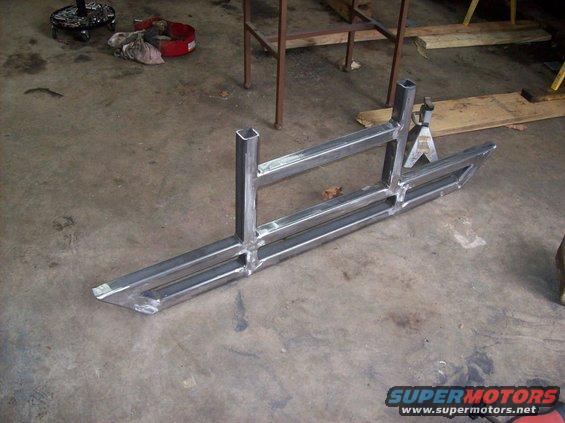 Custom metal sliders fabricated from square tubing, resting on a concrete floor