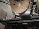 1991 Ford Bronco - A close-up view of a vehicle's undercarriage reveals the transmission housing and surrounding mechanical components.