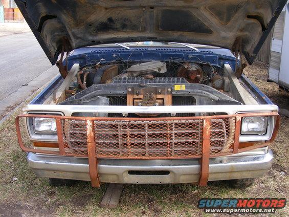 1985 Ford Bronco front view, hood open, engine visible, rusted grille guard
