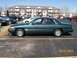 1995 Mercury Grand Marquis - A 1995 Mercury Grand Marquis is parked in a lot with other vehicles and an apartment building in the background.