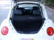 2003 Volkswagen Beetle - Rear view of a white Volkswagen Beetle showing its interior and open trunk, with a California license plate dated 2010.