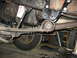 1995 Ford C-350 (Centurion Conversions) - Close-up of the truck's undercarriage, showing the leaf springs and steering linkage.